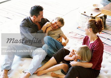 Parents and children playing on mattress