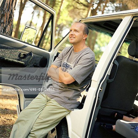 Man leaning against van with open doors