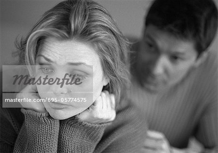 Man standing behind tearful woman, close-up, b&w