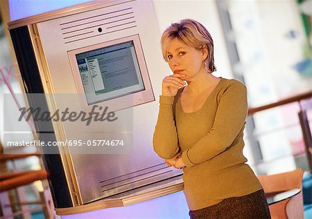 Woman standing in front of computer screen, portrait