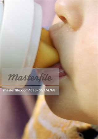 Baby drinking from bottle, close-up on mouth.