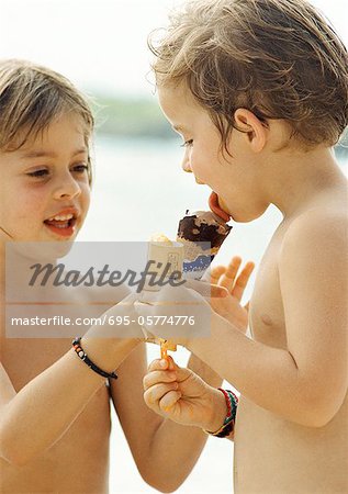 Two children sharing ice cream, portrait.