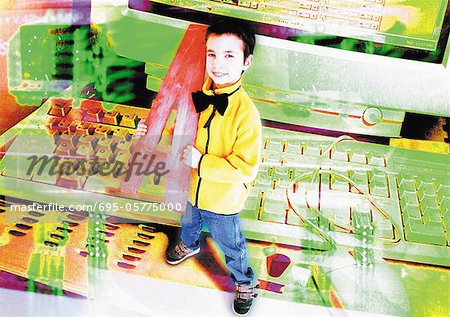 Young boy holding oversized letter, standing next to computer, digital composite.
