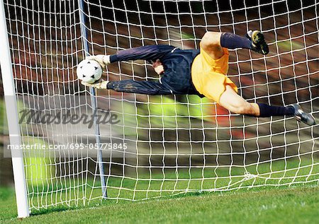 Horizontal image of soccer ball being kicked by footballer against