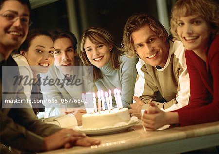 People sitting around birthday cake, portrait