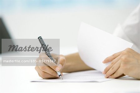 Person signing document with pen, cropped view of hands
