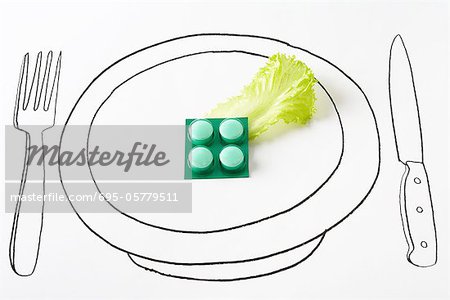 Blister pack of pills and single piece of lettuce on plate