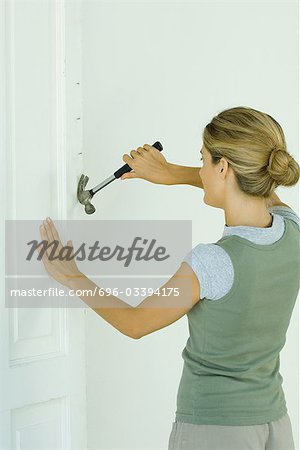 Woman removing nails with hammer