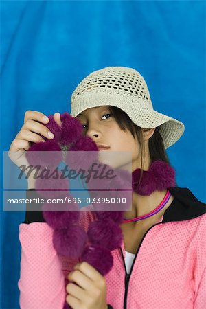 Teenage girl wearing hat, holding boa against face, portrait