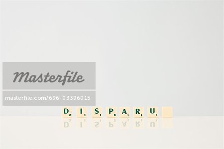 Word game tiles spelling the word "Disparu," ("disappeared" in french), with final tile blank