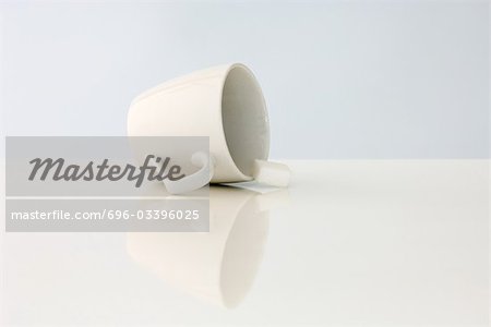 Coffee cup lying on its side, sugar cube spilling out Coffee cup lying on its side, sugar cube spilling out