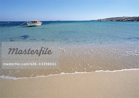 Greece, Cyclades, seashore with small anchored boat