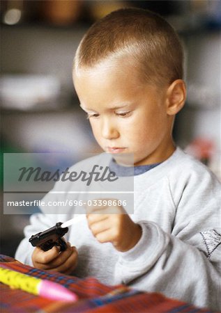 Little boy holding toy gun