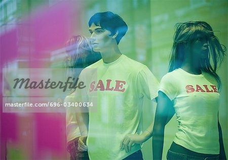 Mannequins in shop window wearing sale tee-shirts