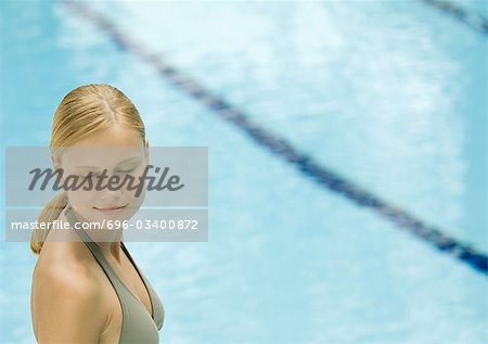 Woman near pool with eyes closed, smiling