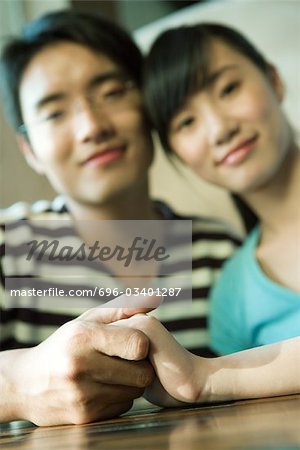 Couple holding hands, focus on hands in foreground