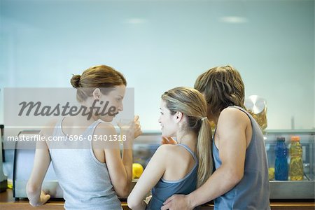 Young adults in exercise clothing, taking break in health club cafeteria