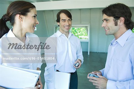 Three business associates looking at each other, discussing, waist up