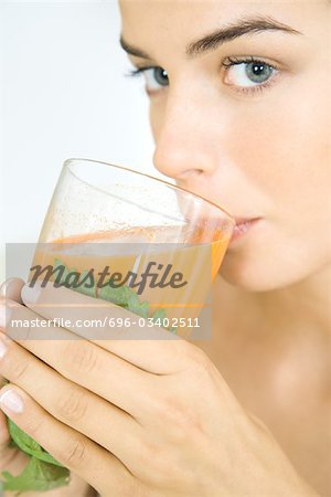 Young woman drinking a glass of fresh vegetable juice