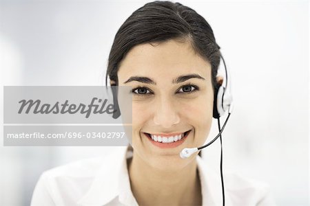 Woman wearing headset, smiling at camera, portrait