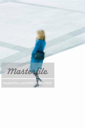 Woman in blue overcoat descending stairs