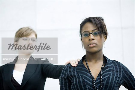 Businesswoman tapping associate on shoulder