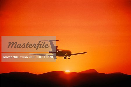 Silhouette of Airplane in Sky at Sunset