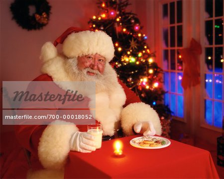 Portrait of Santa Claus Sitting At Table with Milk and Cookies