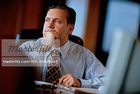 Businessman at Desk, Resting Head on Hand