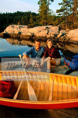 Couple Sitting on Rock with Canoe Temagami, Ontario, Canada