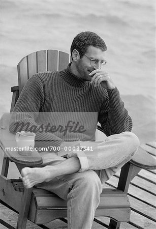 Man Sitting in Chair on Dock
