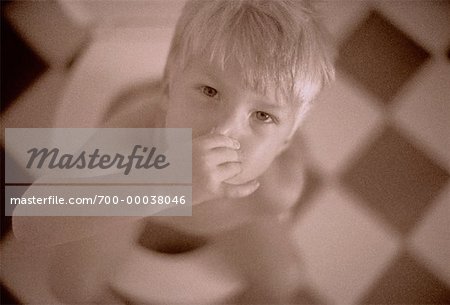 Portrait of Boy Sitting on Toilet