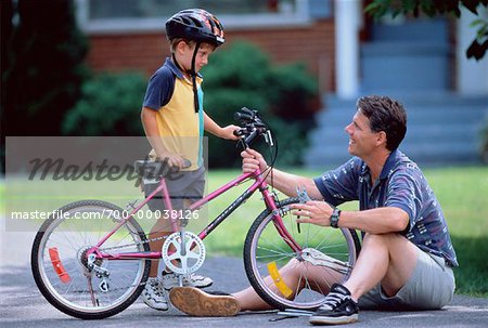 Father and Son Fixing Bicycle Outdoors