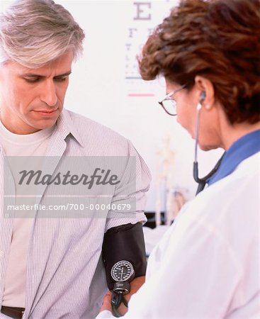 Female Doctor Taking Mature Male Patient's Blood Pressure