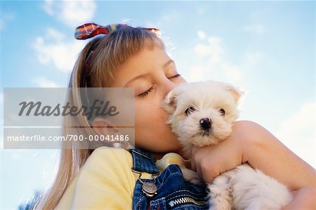 Girl Kissing Puppy Outdoors