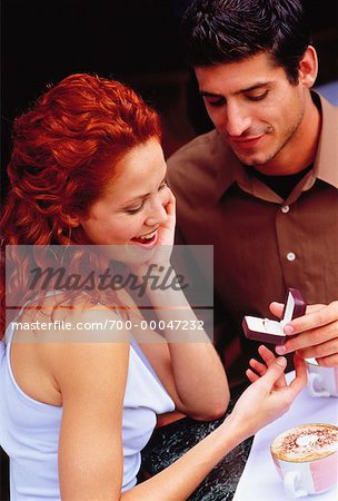 Man Giving Ring to Woman at Outdoor Cafe