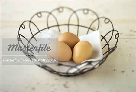 Three Brown Eggs on Napkin in Wire Basket