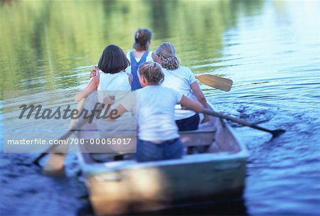 Back View of Four Teenage Girls In Row Boat Stock Photo