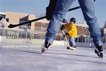 Father and Son Playing Hockey at Outdoor Ice Rink