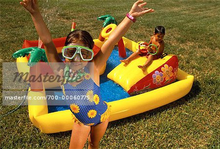 Boy and Girl Wearing Swimwear Playing with Inflatable Pool