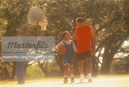 Father and Son on Outdoor Basketball Court with Basketball