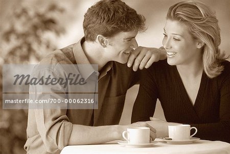 Couple Sitting at Table with Coffee Cups at Cafe