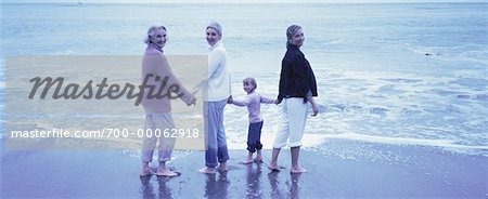Portrait of Four Generations of Women Standing in Surf on Beach