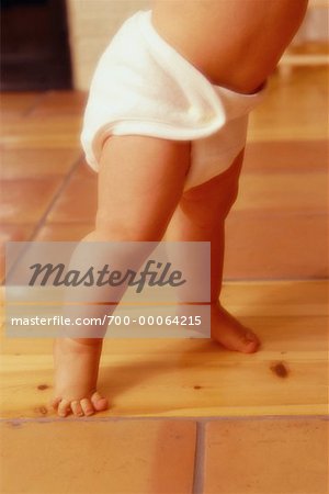 Close-Up of Baby Walking on Wooden Floor