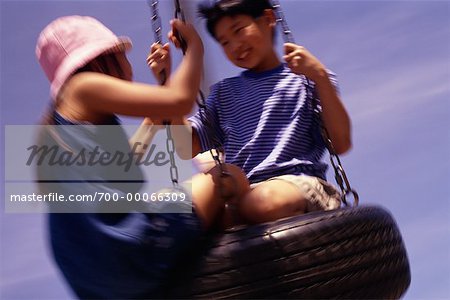 Boy and Girl Playing on Tire Swing
