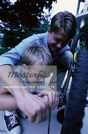 Father and Son Fixing Bicycle Outdoors