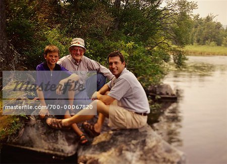 Portrait of Grandfather, Father And Son on Rocks near Lake Belgrade Lakes, Maine, USA