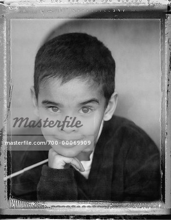 Portrait of Boy Sitting in Chair Resting Head on Hand