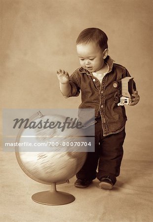 Boy Standing near Spinning Globe