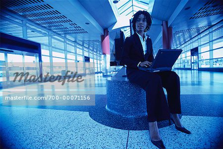 Businesswoman Using Laptop in Terminal